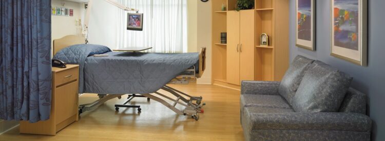 plush hospital room with a bed, couch and storage furniture
