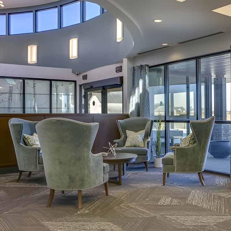 chairs around a coffee table in a entrance area with a heigh ceiling