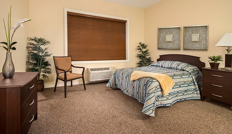 bed and chair by large window