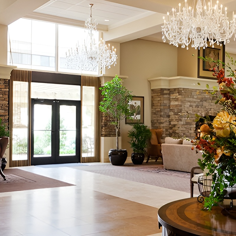 large entrance with chandeliers and indoor plants